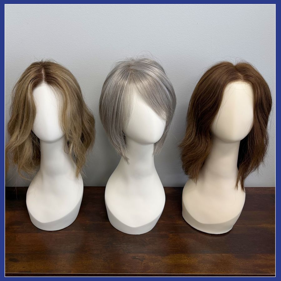 Three wigs and toppers styled on display forms at the Hair Response studio